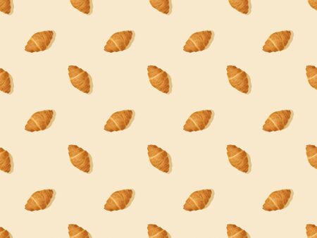 top view of fresh croissants on beige, seamless background patternの写真素材