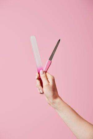 Cropped view of woman holding nail files isolated on pinkの写真素材