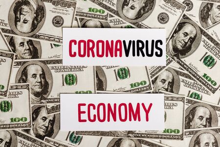 top view of coronavirus and economy cards on dollar banknotes, economic crisis conceptの写真素材