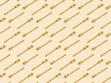 top view of golden forks isolated on beige, seamless background patternの写真素材