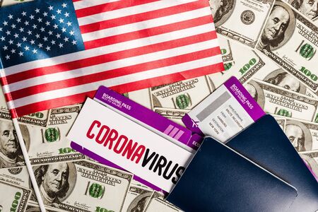 top view of american flag and passports with air tickets on dollar banknotes, coronavirus economic...