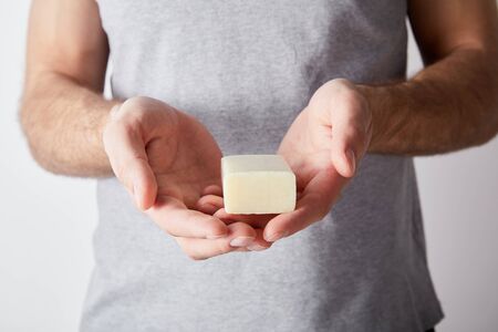 partial view of man holding soap on grey background backgroundの写真素材