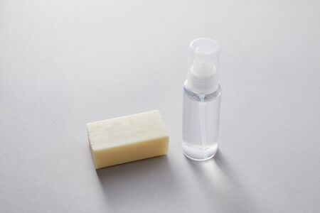 hand sanitizer in spray bottle and antibacterial soap on white background