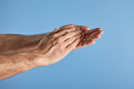 cropped view of man washing hands isolated on blue