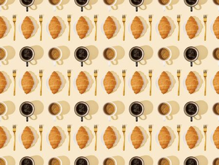 top view of golden forks, croissants and coffee on beige, seamless background patternの写真素材