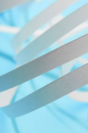close up view of white paper stripes on blue background