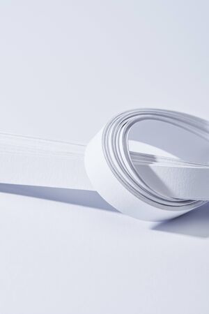 close up view of paper stripes in knot on white backgroundの写真素材