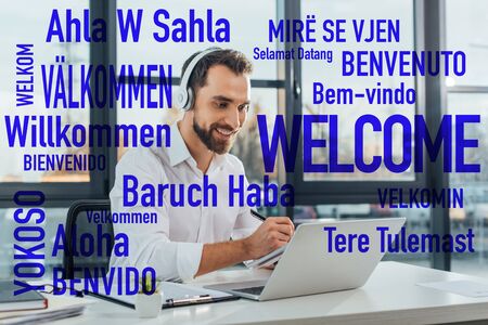 positive translator working online with headphones and laptop in office, welcome translation illustrationの写真素材