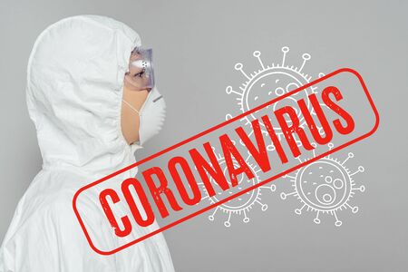 side view of asian epidemiologist in hazmat suit and respirator mask isolated on grey, coronavirus illustrationの写真素材