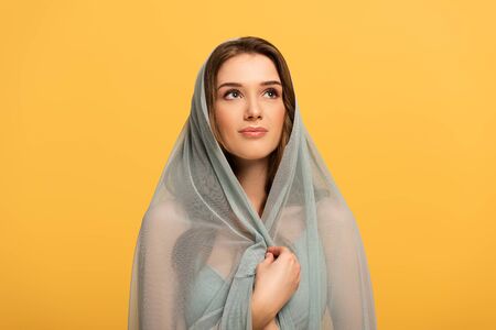 beautiful elegant smiling girl in dress and veil isolated on yellow
