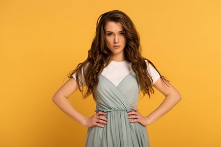 confident spring woman with long hair isolated on yellowの写真素材