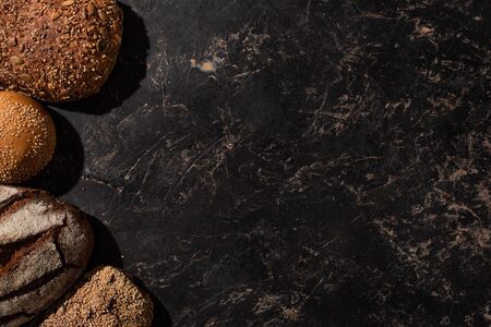 top view of fresh baked bread on stone black surface