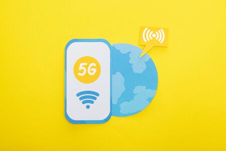 top view of 5g lettering on paper smartphone near globe on yellow backgroundの写真素材