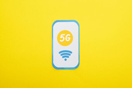 top view of 5g lettering on paper smartphone on yellow background