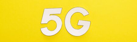 top view of white 5g lettering on yellow background, panoramic shotの写真素材