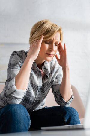 mature woman with closed eyes suffering from migraineの写真素材