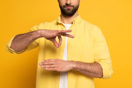 Cropped view of man gesturing while using sign language on yellow backgroundの写真素材
