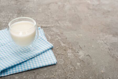 High angle view of glass of homemade yogurt on plaid cloth on grey backgroundの写真素材