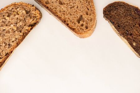 top view of fresh whole wheat bread slices on white background with copy spaceの写真素材