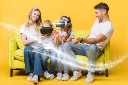 happy parents with children in virtual reality headsets sitting on sofa on yellow, glowing illustrationの写真素材