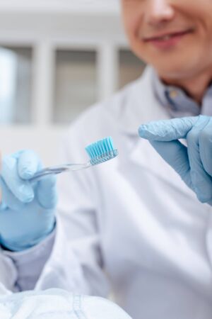 selective focus of dentist pointing with finger at toothbrushの写真素材
