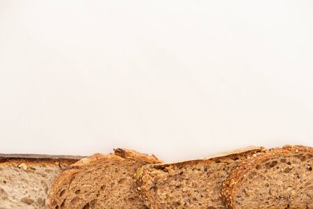 top view of fresh whole grain bread slices on white background with copy space