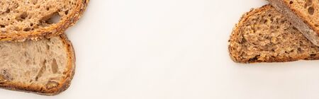 top view of fresh whole grain bread slices on white background with copy space, panoramic shot