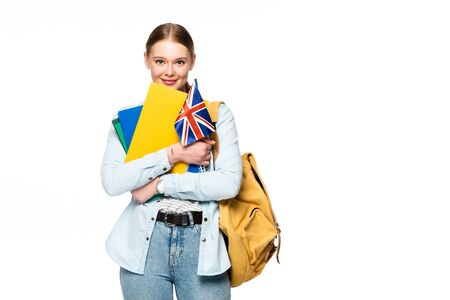 smiling girl with backpack holding copybooks and uk flag isolated on whiteの写真素材