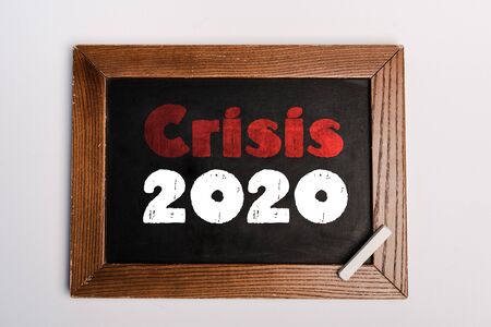 crisis 2020 lettering written on chalkboard on white background, coronavirus conceptの写真素材