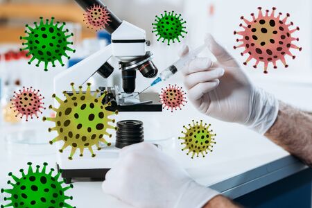 cropped view of scientist in latex gloves holding syringe near microscope, bacteria illustrationの写真素材