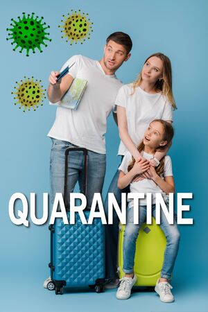 parents and shocked daughter with travel bags, map and passports on blue, quarantine letteringの写真素材