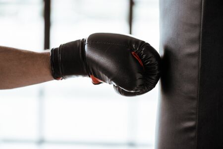 cropped view of sportsman in boxing glove training with punching bagの写真素材