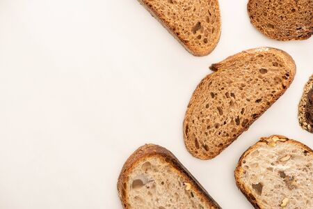 top view of tasty whole wheat bread slices on white background with copy space