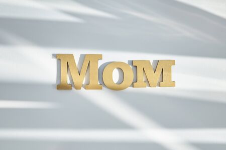 top view of mom lettering on white background with shadowsの写真素材