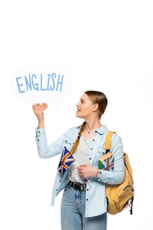 smiling pretty student with backpack holding book, speech bubble with English lettering and British flag isolated on whiteの写真素材