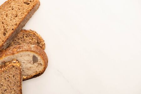 top view of fresh whole grain bread slices on white background with copy space