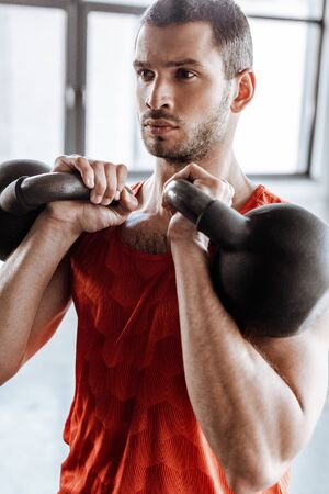 athletic and bearded man exercising with heavy dumbbellsの写真素材