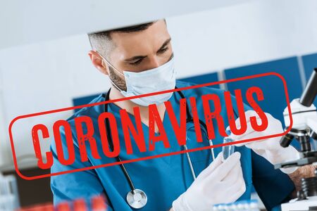 young doctor in medical mask and latex gloves holding glass container with medicine, coronavirus...