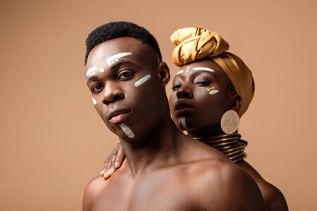 sexy naked tribal afro couple posing on beigeの写真素材