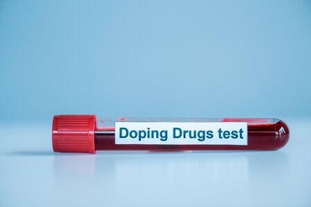 test tube with sample and doping drugs test lettering on blueの写真素材