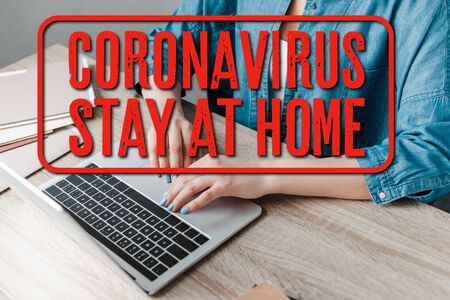 cropped view of woman working with laptop in office, coronavirus and stay at home illustrationの写真素材
