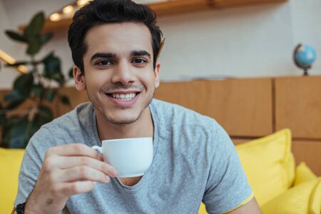 Man with cup of coffee smiling and looking at cameraの写真素材