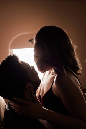 sexy woman hugging neck of man while flying in plane