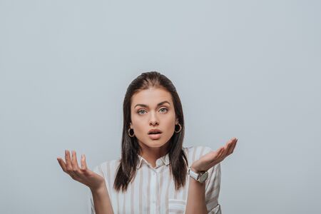 Confused woman looking at camera isolated on grey