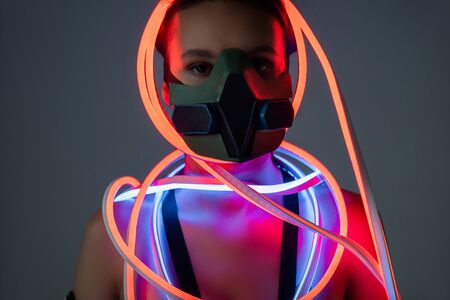 futuristic african american woman in respirator and neon lightingの写真素材