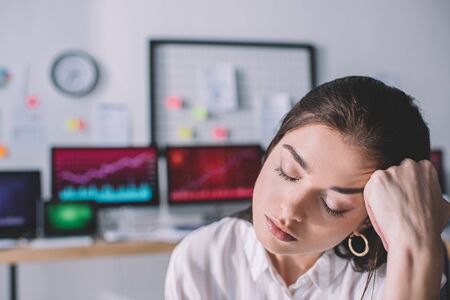 Exhausted information security analyst with hand near head in office
