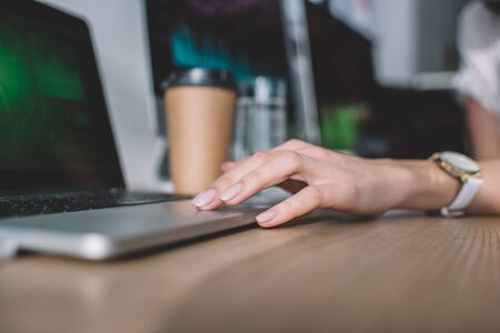 Cropped view of data analyst using laptop at table in officeの写真素材