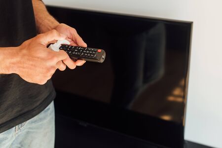 cropped view of man holding bottle with antibacterial liquid near remote controllerの写真素材