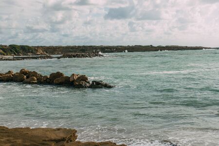 wet stones in blue mediterranean sea against skyの写真素材