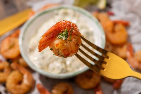 selective focus of fried shrimp on golden forkの写真素材